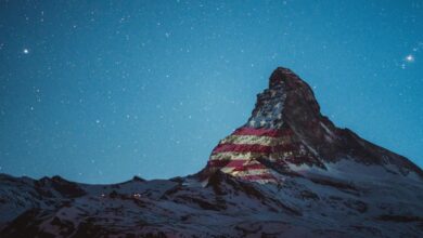 Banderas de distintos países se proyectan en los Alpes Suizos por solidaridad ante COVID-19