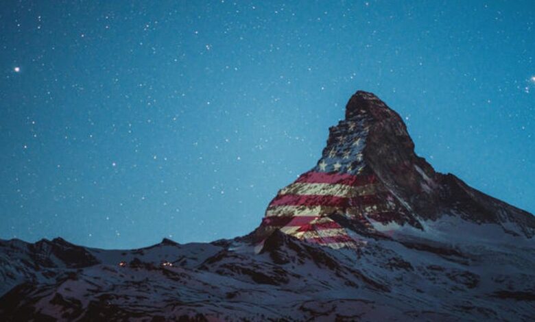 Banderas de distintos países se proyectan en los Alpes Suizos por solidaridad ante COVID-19